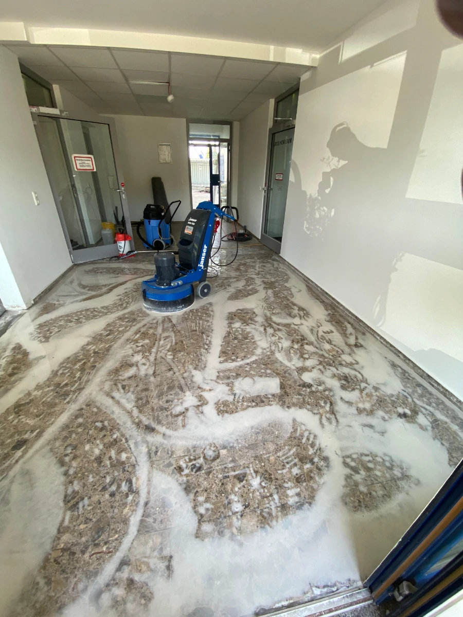 Spezialschleifmaschine entfernt Estrich- und Schmutzreste auf gewerblicher Fläche (Boden schleifen)
