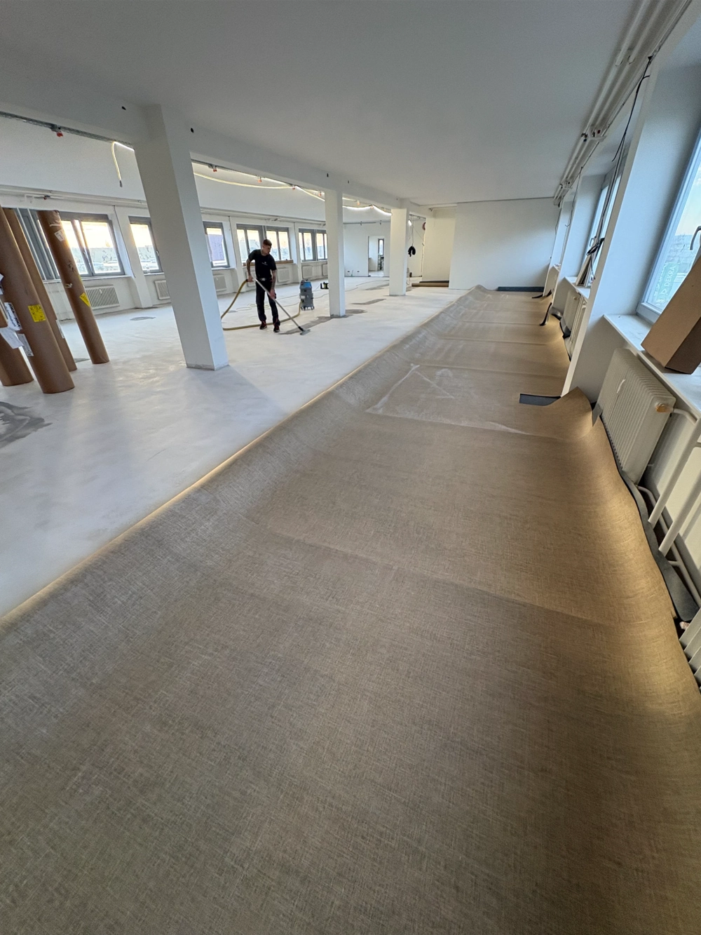 Großer Gewerberaum beim Boden schleifen mit professioneller Schleifmaschine und freigelegtem Untergrund