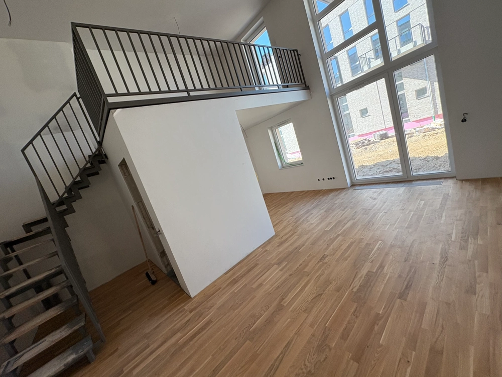 Offener Wohnraum mit Galerieebene und Stahl-Holz-Treppe, frisch verlegter Eichenparkettboden Parkett verlegen