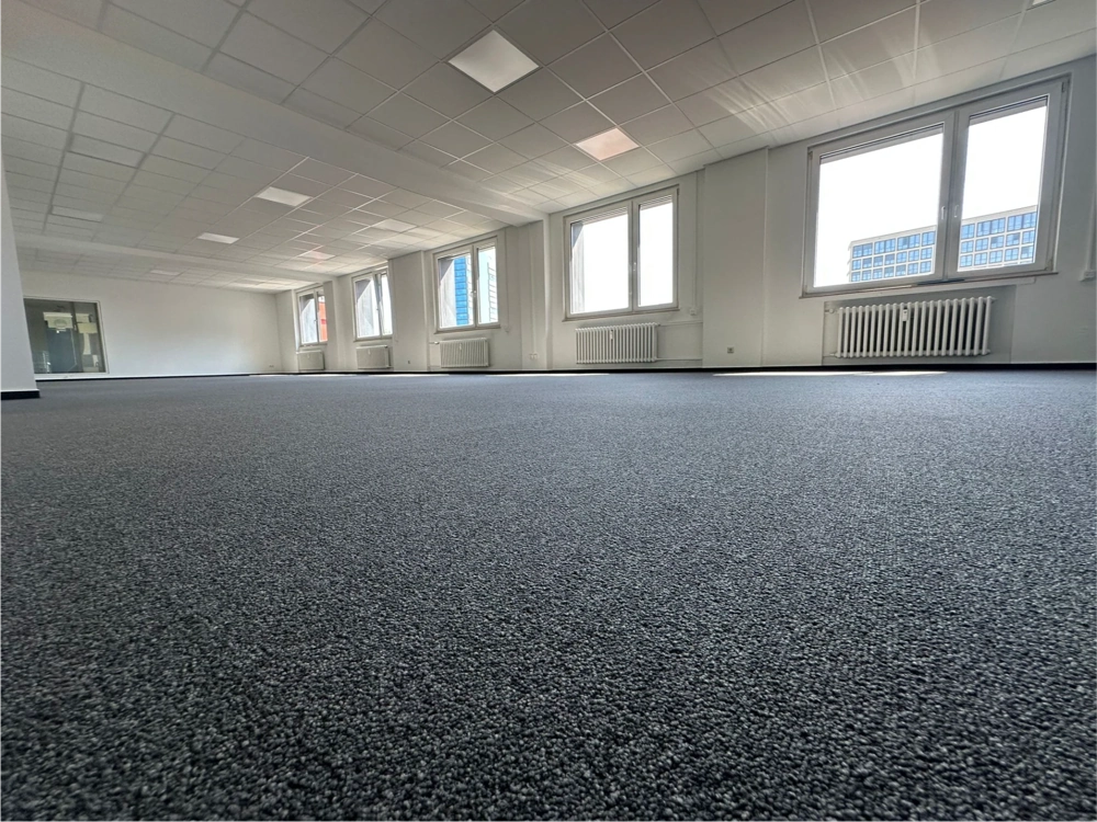 Gewerblich verlegter grauer Teppichboden in großem Büro, Teppich verlegen