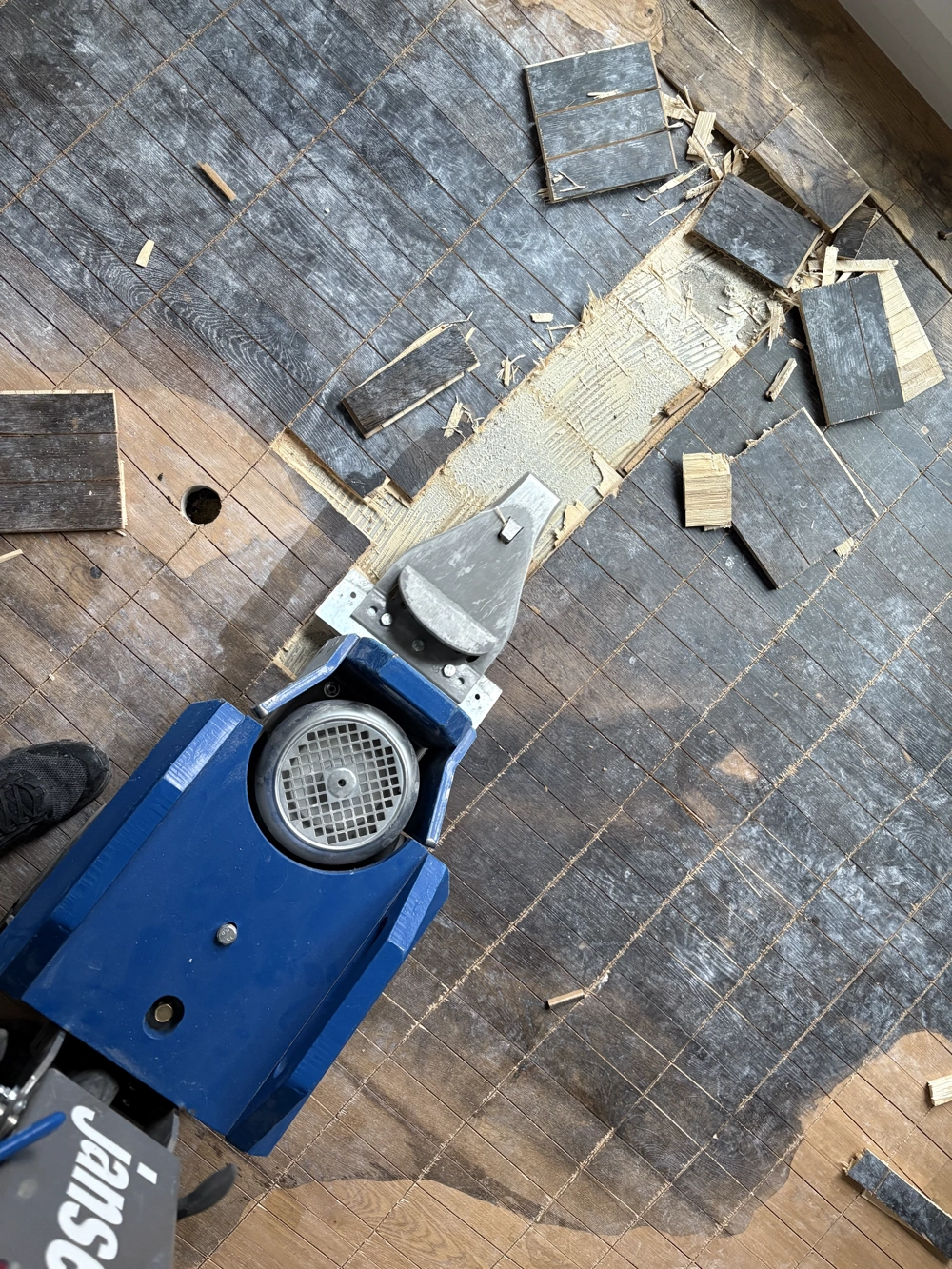 Mechanisches Laminat entfernen mit Abfräse und Kleberückständen auf Holzboden