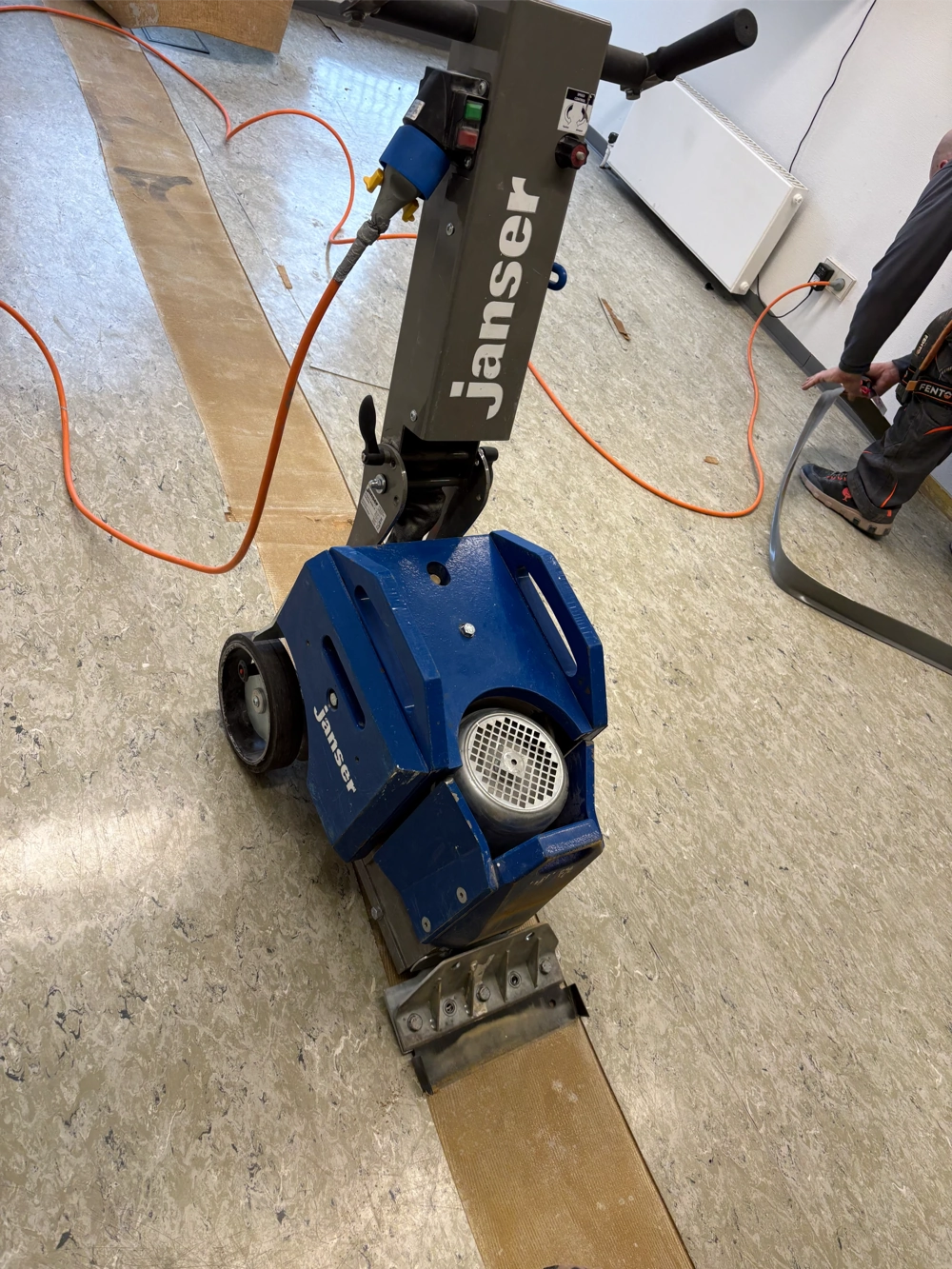 Maschine entfernt alte PVC Bodenbeläge in schmalen Streifen auf gewerblichem Untergrund