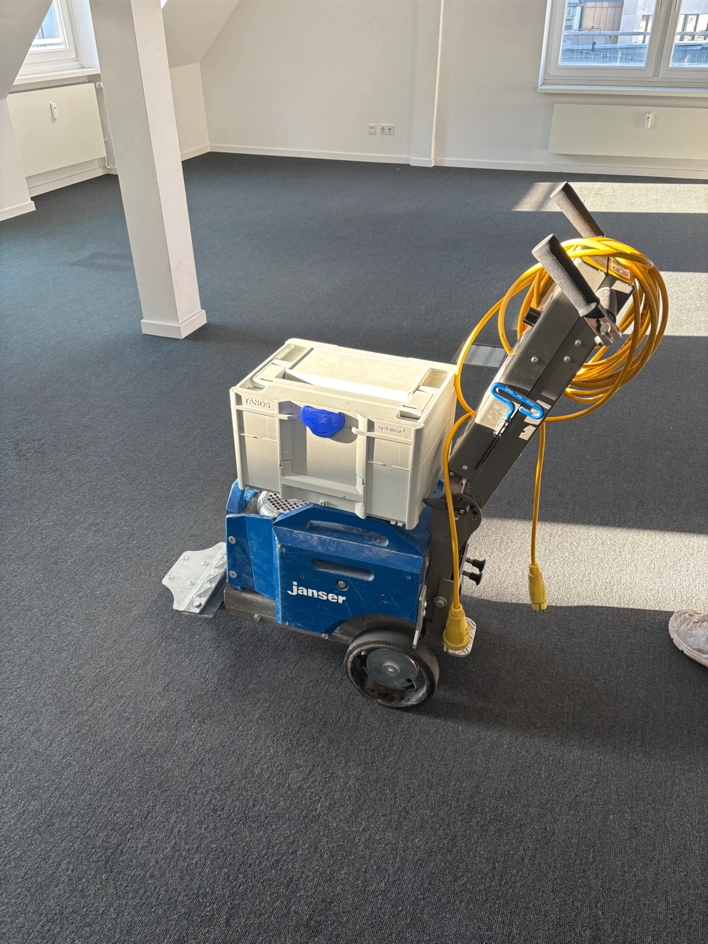 Maschine zum Entfernen von Teppichboden in leerem, frisch verlegtem Raum