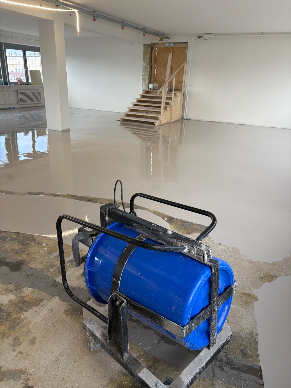 Mobile Mischstation für Epoxidharzboden auf frisch geglättetem Untergrund in hellem Gewerberaum