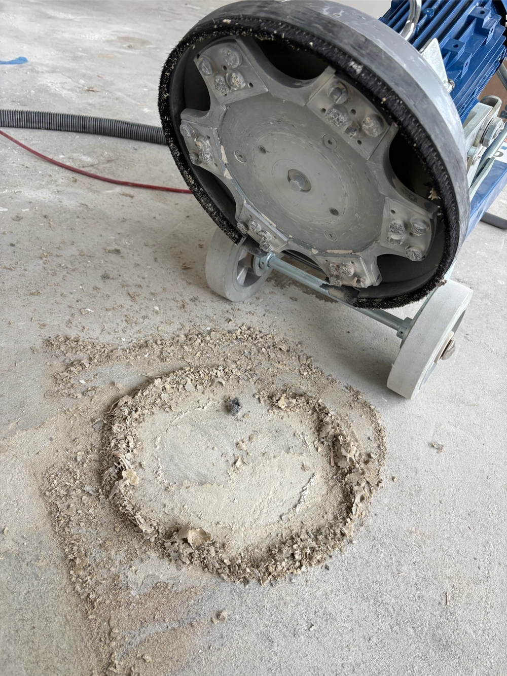 Schleifmaschine beim Boden schleifen auf Betonboden mit kreisrund freigelegter Fläche