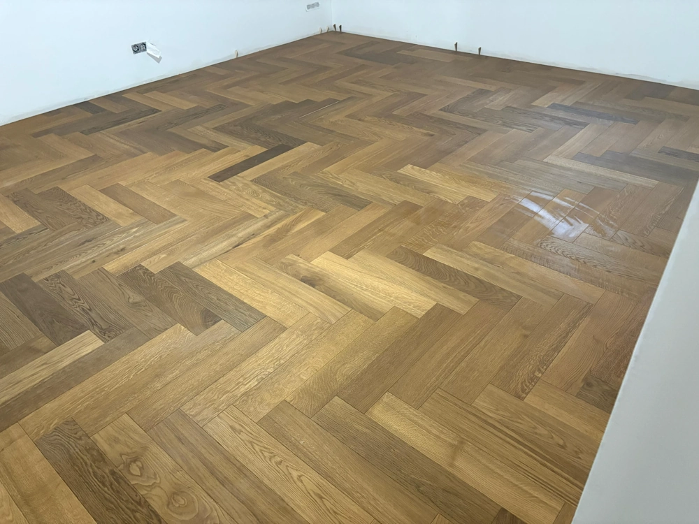 Neu verlegtes Fischgrätparkett aus Eichenholz in leerem Raum Parkett verlegen